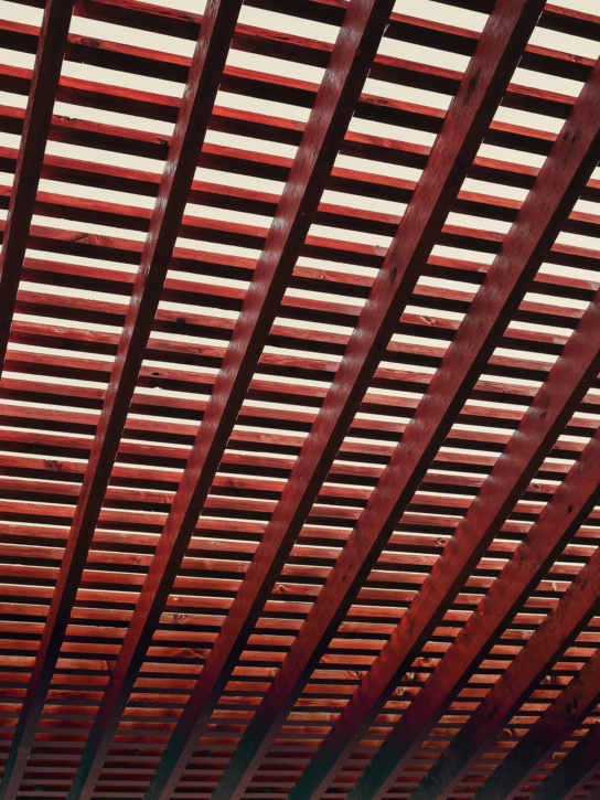 A wooden slatted ceiling with red and orange gradients.