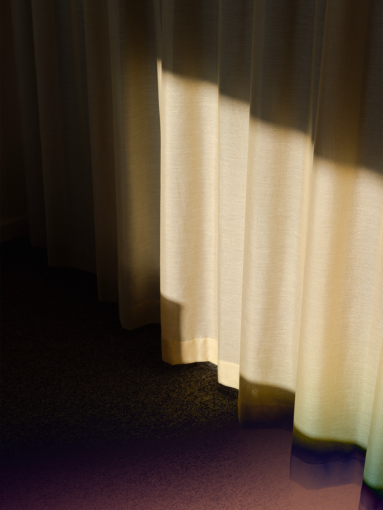 Cream-coloured curtains with sunlight shining through them.