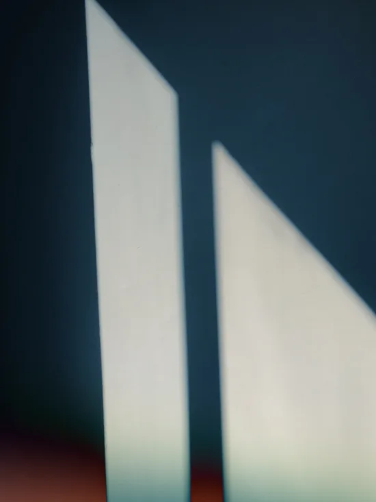 Two white triangular shades on a blue and orange background.