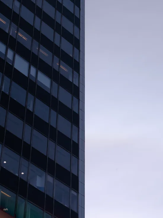 A modern building with reflective glass windows against a clear sky during dusk.