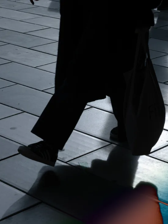 A person walking on a colorful tiled floor in the dark.