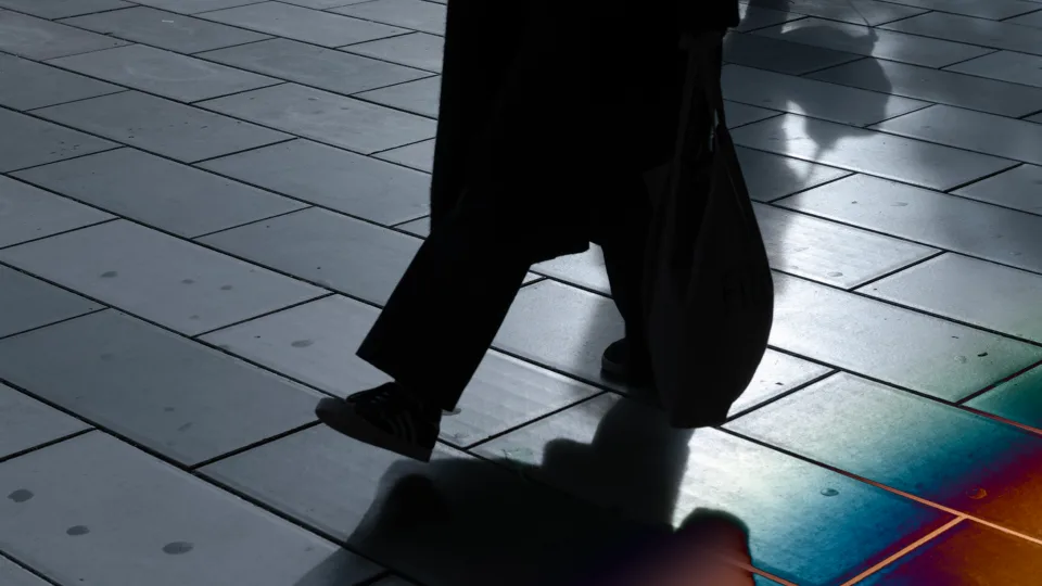 A person walking on a colorful tiled floor in the dark.