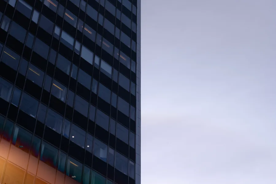 A modern building with reflective glass windows against a clear sky during dusk.