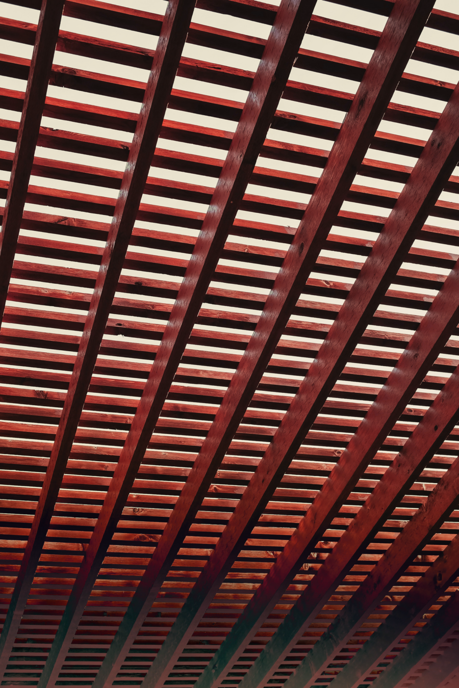 A wooden slatted ceiling with red and orange gradients.