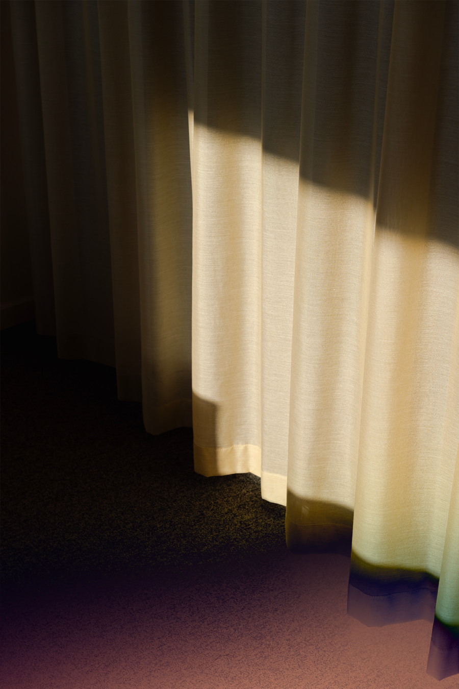 Cream-coloured curtains with sunlight shining through them.
