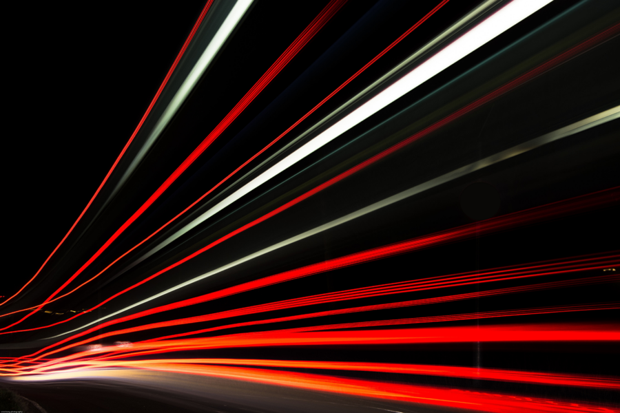 Red and white light trails on a black background.