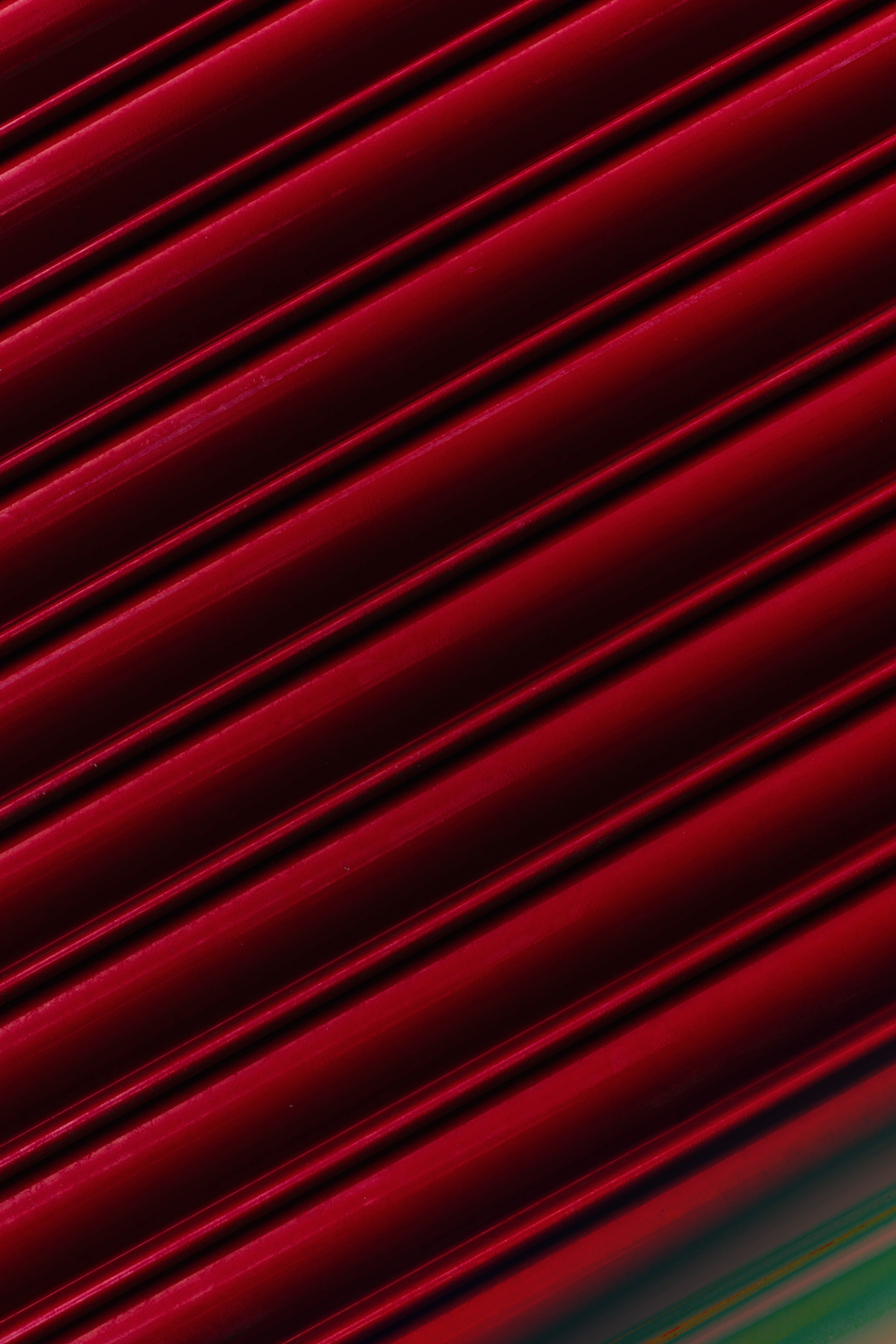 Red, glossy, and parallel lines with a slight reflection of green and blue lights at the bottom.