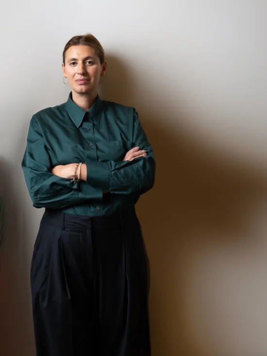 Woman in a green shirt and a shadow forming a cape.